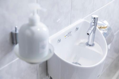 a bathroom with a sink and a soap dispenser at パームヴィラ-貸切プライベート-最大10名様のバケーションステイ-駐車場付き in Yaese