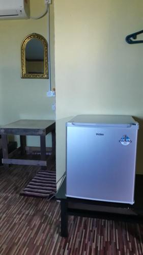 a small refrigerator in a room with a table at juara seaview chalet, kampung juara in Kampong Juara