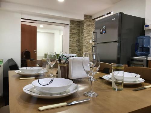 a wooden table with plates and wine glasses on it at Giannoullas Luxury2Bedroom House in Kalopanagiotis in Kalopanayiotis