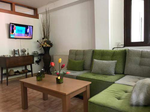 a living room with a green couch and a table at Giannoullas Luxury2Bedroom House in Kalopanagiotis in Kalopanayiotis