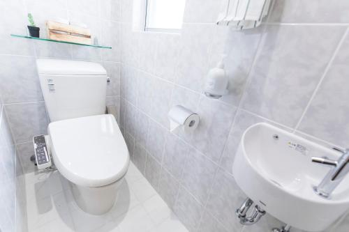 a white bathroom with a toilet and a sink at パームヴィラ-貸切プライベート-最大10名様のバケーションステイ-駐車場付き in Yaese