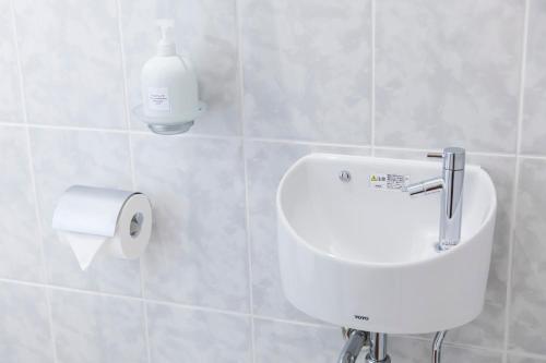 a bathroom with a soap dispenser and a toilet paper roll at パームヴィラ-貸切プライベート-最大10名様のバケーションステイ-駐車場付き in Yaese