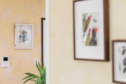 a hallway with pictures on the wall and a plant at パームヴィラ-貸切プライベート-最大10名様のバケーションステイ-駐車場付き in Yaese