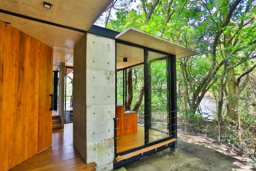 a house in the woods with glass walls at Kalundewa Retreat in Dambulla