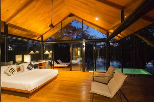 a bedroom in a house with a bed and a chair at Kalundewa Retreat in Dambulla