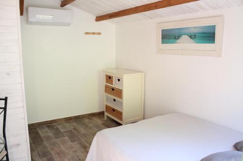 une chambre avec un lit blanc et une commode dans l'établissement Petit chalet climatisé avec jacuzzi privé, au Beausset