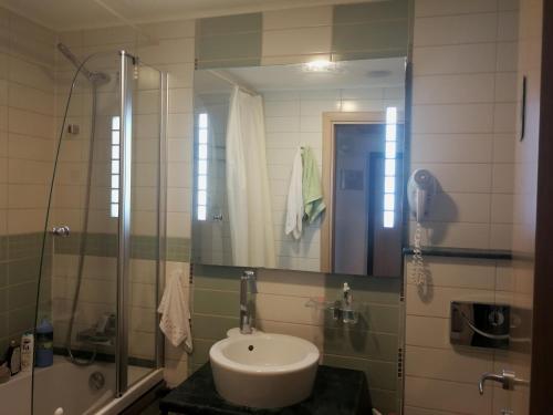 uma casa de banho com um lavatório e um chuveiro em Emerald Beach Resort & Spa,studio ikat310 em Ravda