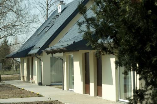 a house with a gambrel roof and a sidewalk at Cicha Przystań in Nowy Dwór Gdański