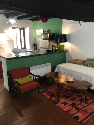 a living room with a table and a kitchen at Maison de village in Ortiporio