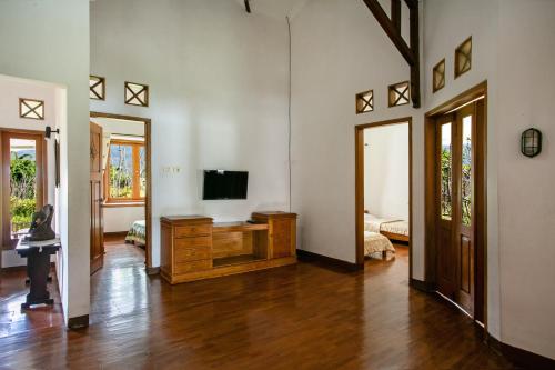 una sala de estar con TV en un tocador de madera en Shanty's House, en Batu