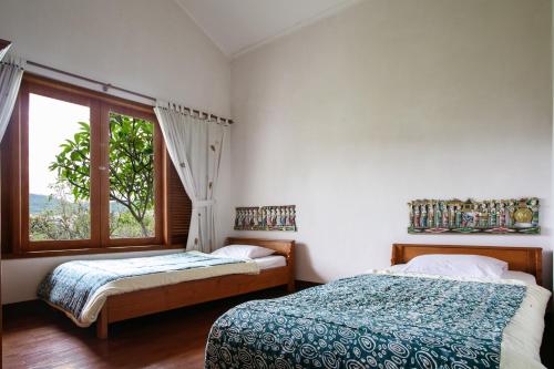 a bedroom with two beds and a window at Shanty's House in Batu