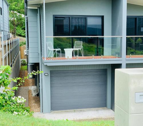 a garage door in a house with a table and chairs at AIRLIE BEACH Delight. Hop, skip jump to everything in Cannonvale