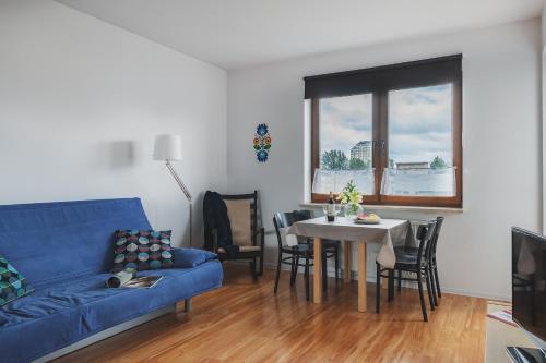 ein Wohnzimmer mit einem blauen Sofa und einem Tisch in der Unterkunft P&O Apartments Namyslowska in Warschau