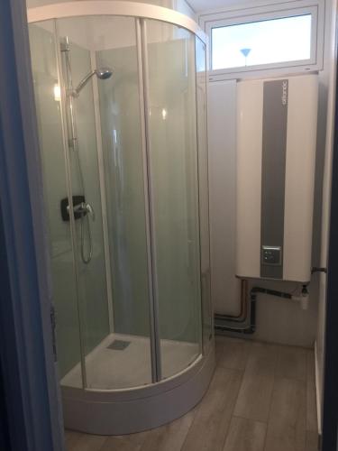 La salle de bains est pourvue d'une douche en verre et d'une fenêtre. dans l'établissement Entre mer et falaises, au Tréport