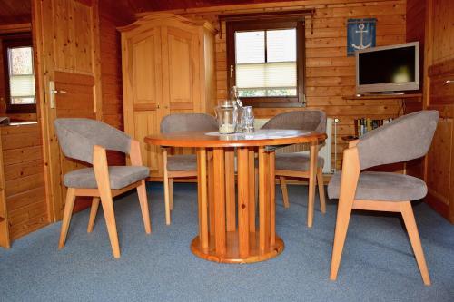 a dining room with a wooden table and chairs at Blockhaus in Gnarrenburg