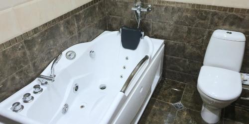 a bathroom with a bath tub and a toilet at Batusi Apartment in Batumi
