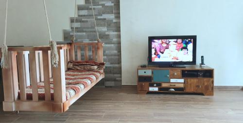 1 dormitorio con cuna y mesa con TV en Batusi Apartment, en Batumi