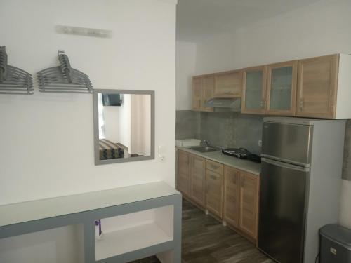 a kitchen with a stainless steel refrigerator and wooden cabinets at Toula's Apartments in Faliraki