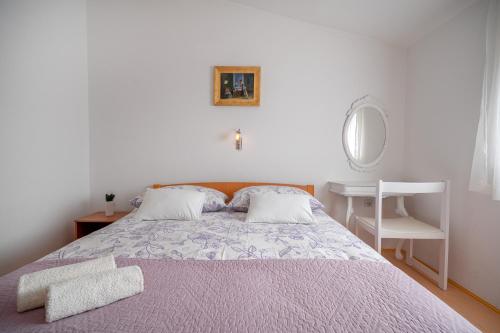 a bedroom with a bed and a table and a mirror at Apartman Skroza in Vodice
