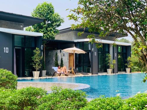 楠府的住宿－利拉哇地南班蘇安度假酒店，坐在游泳池旁椅子上的人