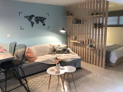 a living room with a couch and a bed at ORFEAS SUITE in Nea Peramos