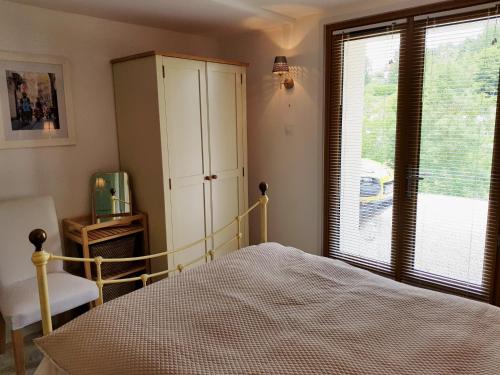 a bedroom with a bed and a cabinet and a window at Le Pré Pigeon 86250 Charroux Vienne in Charroux