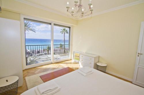 - une chambre avec un lit et une grande fenêtre donnant sur l'océan dans l'établissement PROMENADE HOLIDAY - CARIATIDE PROMENADE SEA VIEW, à Nice