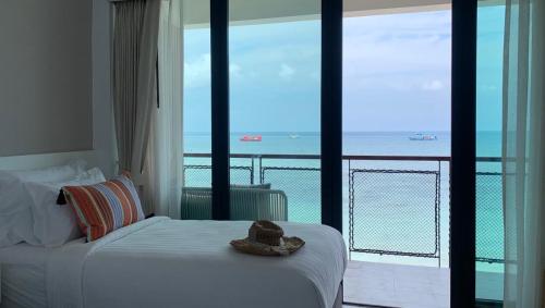 a bedroom with a bed with a view of the ocean at Blue Tao Beach Hotel - SHA Plus in Koh Tao