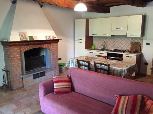 sala de estar con sofá y chimenea en Podere Baloo Suvereto en Suvereto