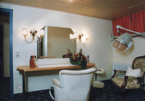 a room with a desk and a mirror and a chair at Wellness und Romantik Hotel Helmboldt in Bad Sachsa
