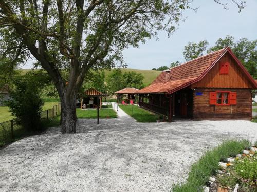 a barn with a tree and a house at Pod orehom drvena kuća i sauna in Krapina