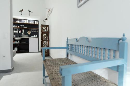 a blue bench in a room with a kitchen at Naturarte Guesthouse in Terrasini