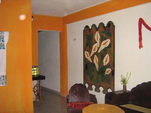 a living room with a painting on the wall at Posada El Jardin in Ticul