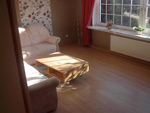 a living room with a chair and a coffee table at Pension-Stürrad in Neuharlingersiel