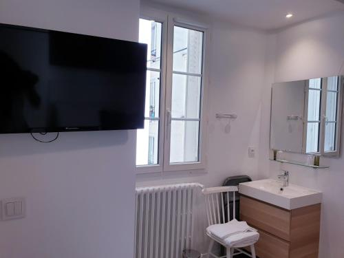 a bathroom with a sink and a tv on the wall at Apartment Quartier Latin - Mouffetard in Paris