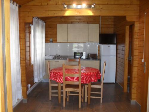 a kitchen with a table and chairs and a refrigerator at Lobateira Villas in Fernao Ferro