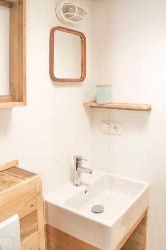 a bathroom with a white sink and a mirror at STOERbuiten Lodges Mar Y Sierra in San Costanzo
