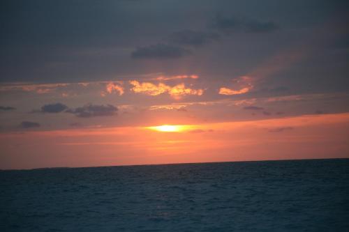 a sunset over the ocean with the sun setting at The Atrium Resort in Grace Bay