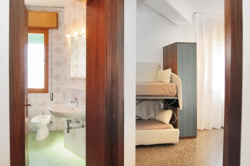 two views of a bathroom with a sink and a bathroom with a toilet at Venus Best Price in Caorle