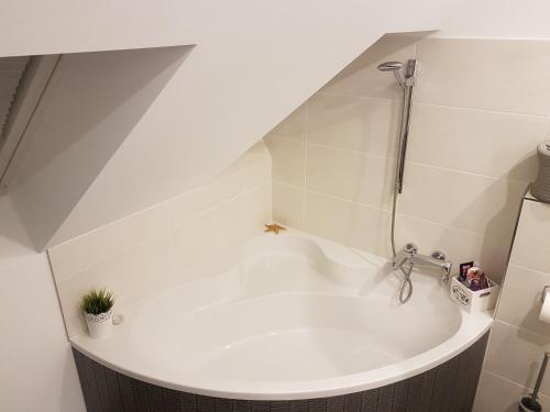 a white bath tub with a shower in a bathroom at Alex in Holzwickede