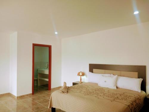 a bedroom with a large bed and a bathroom at BB INN in Nuevo Vallarta 