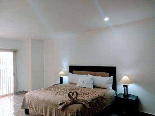 a bedroom with a bed with two swans on it at BB INN in Nuevo Vallarta 