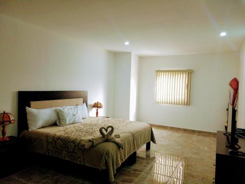 a bedroom with a bed and a window and a television at BB INN in Nuevo Vallarta 