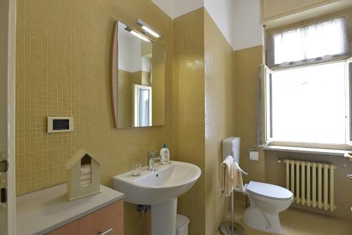 a bathroom with a sink and a toilet and a mirror at Casa Dollu in Rivarolo Canavese