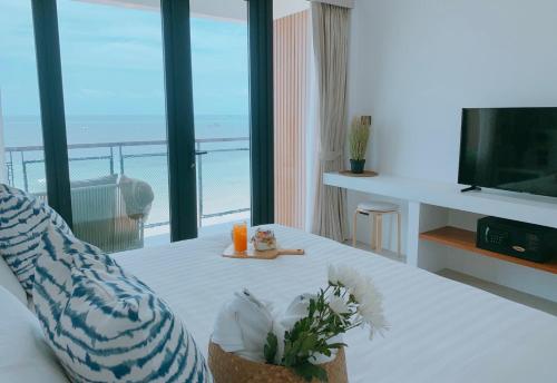 a living room with a view of the ocean at Blue Tao Beach Hotel - SHA Plus in Koh Tao