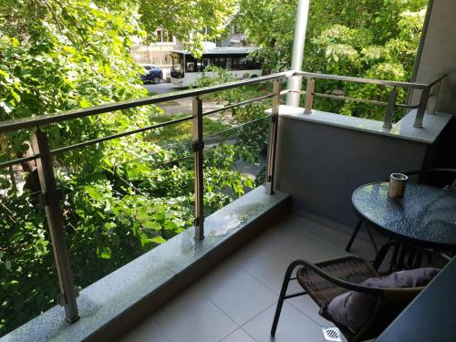 a balcony with a table and a view of a street at The Place - Apartament in Plovdiv in Plovdiv