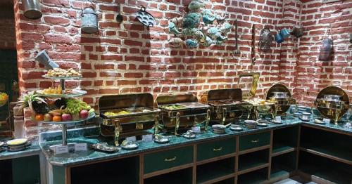 Een buffet met diverse gerechten uitgestald voor een bakstenen muur. bij Heritage Hotel Suites and Spa in Pokhara