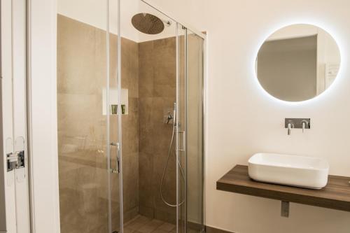 bagno con doccia, lavandino e specchio di SuitesGaribaldi IUN R9481 a Cagliari