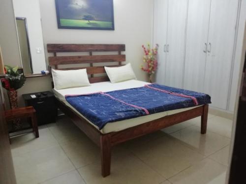a bedroom with a bed with a wooden headboard at The Raveesh E24 - 2BHK Serviced Apartment in New Delhi