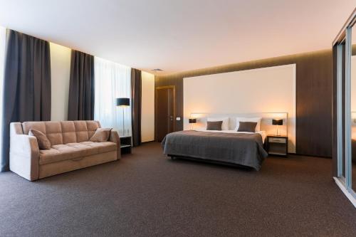 a hotel room with a bed and a couch at WISH Aqua&SPA Resort in Vishenki